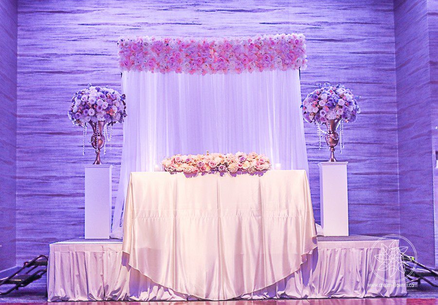 Elegant Hotel Wedding. Short reception centerpiece of hydrangea, roses, spray roses, dahlias, surrounded by floating candles.